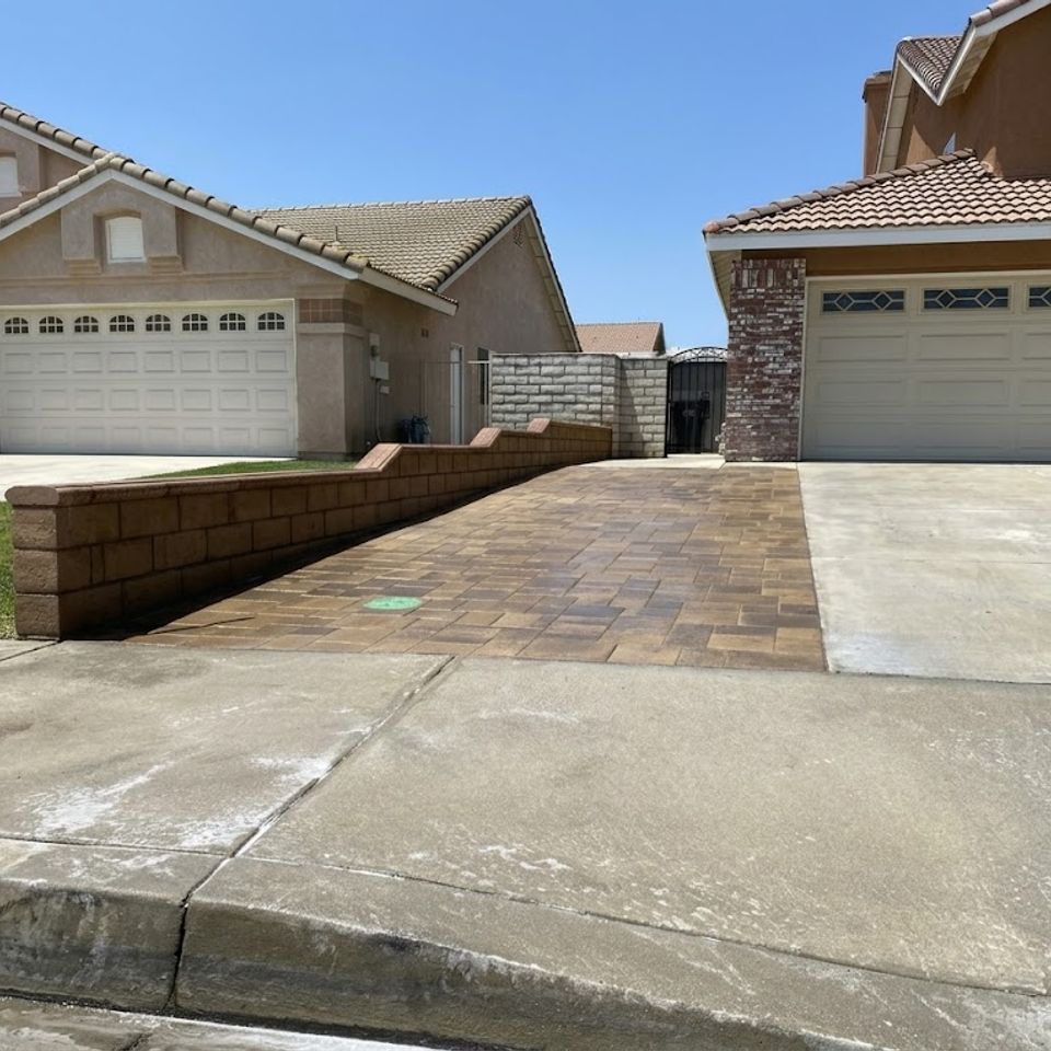 Residential paver driveway and front walkway installation with decorative retaining wall