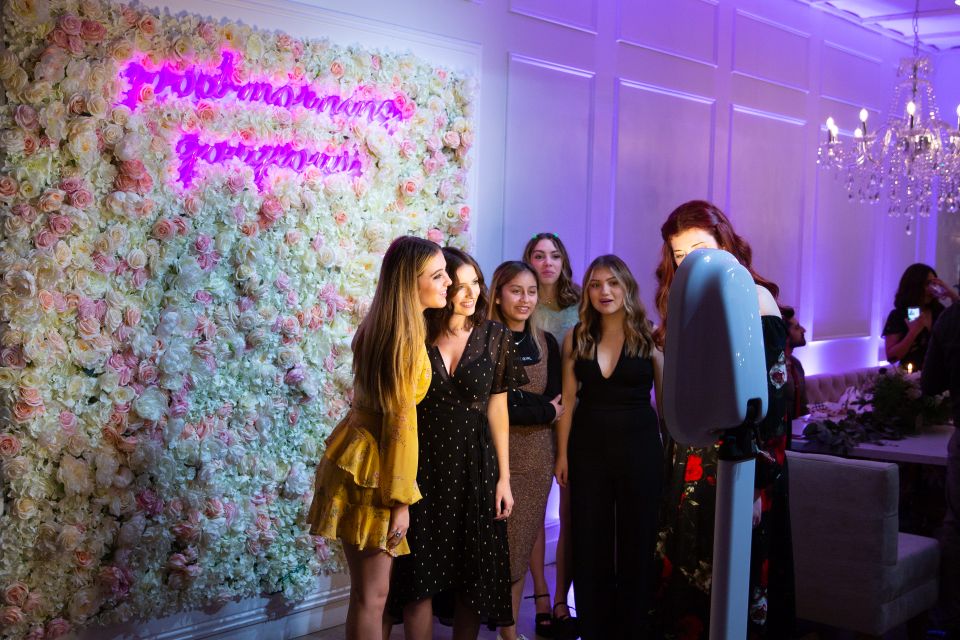 Guests posing using a digital photo booth at an indoor event
