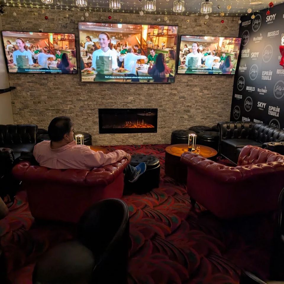 A customer sitting in the lounge area watching sporting events on one of the three big screen tv's at Jilly's.