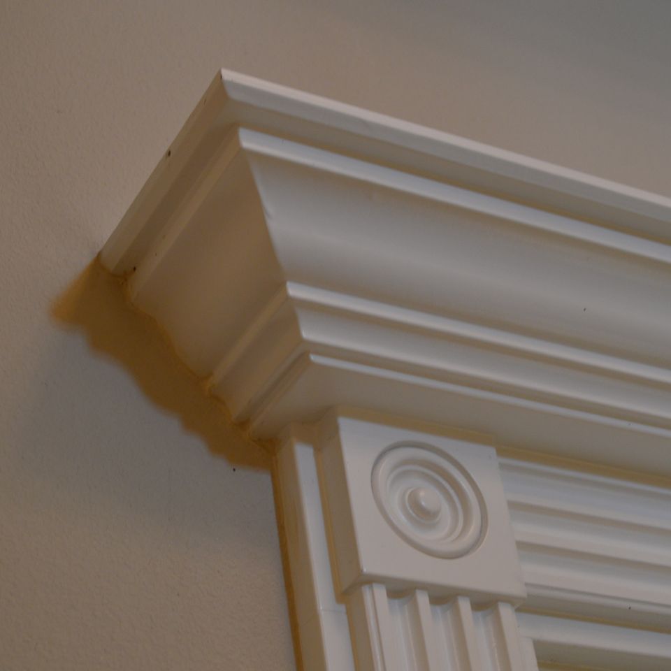 Crown molding header over fluted casing and rosette block in a finished custom home