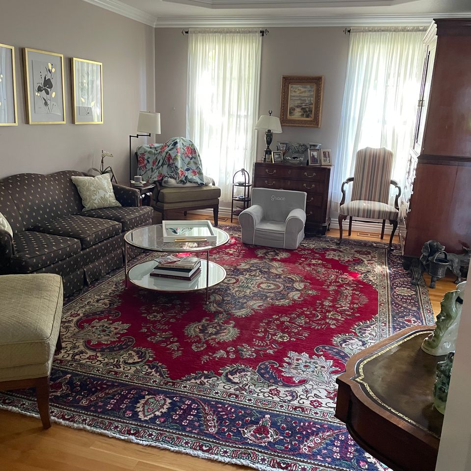 Tidy living room with polished hardwood floors and area rug after a house cleaning service in Virginia Beach VA