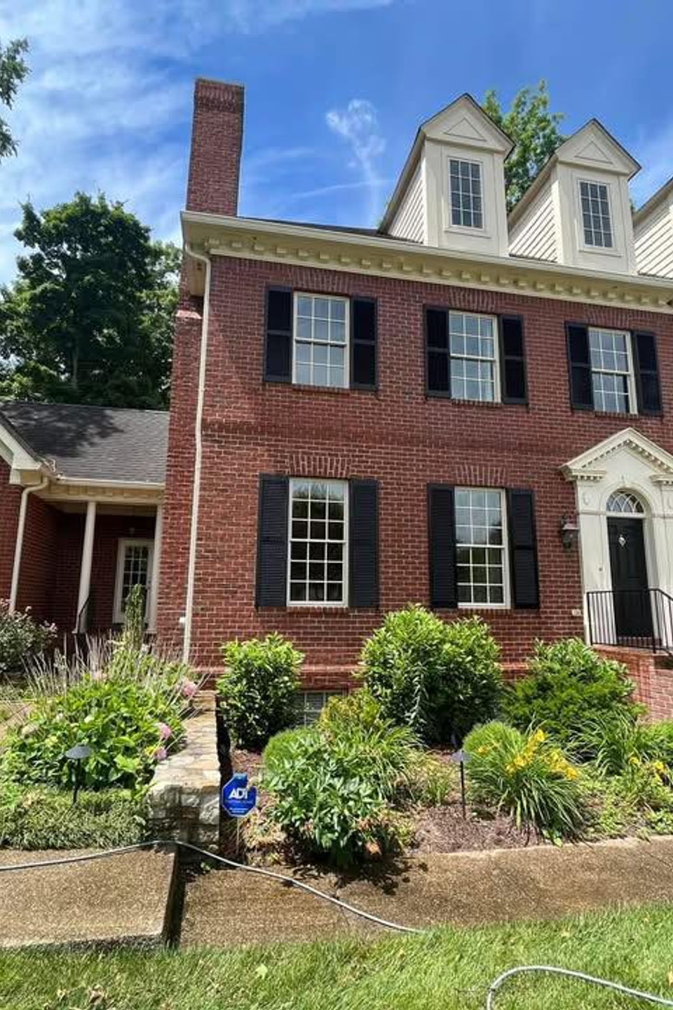 Removing mold and algae from two-story residential brick home exterior