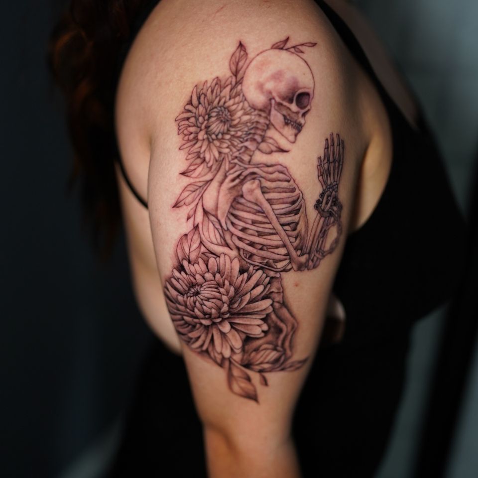 Image of a skeleton surrounded by flowers top and bottom