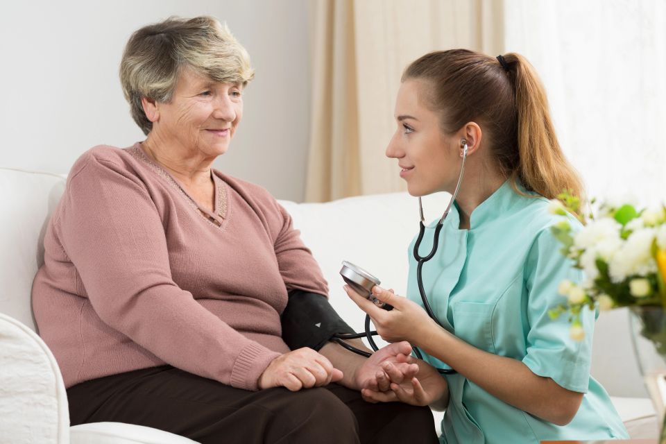 Nurse measuring blood pressure of her senior lady patient