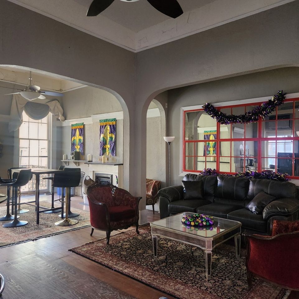 232 Bourbon Street balcony, view of inside sitting area with leather sofa and chairs and a table.