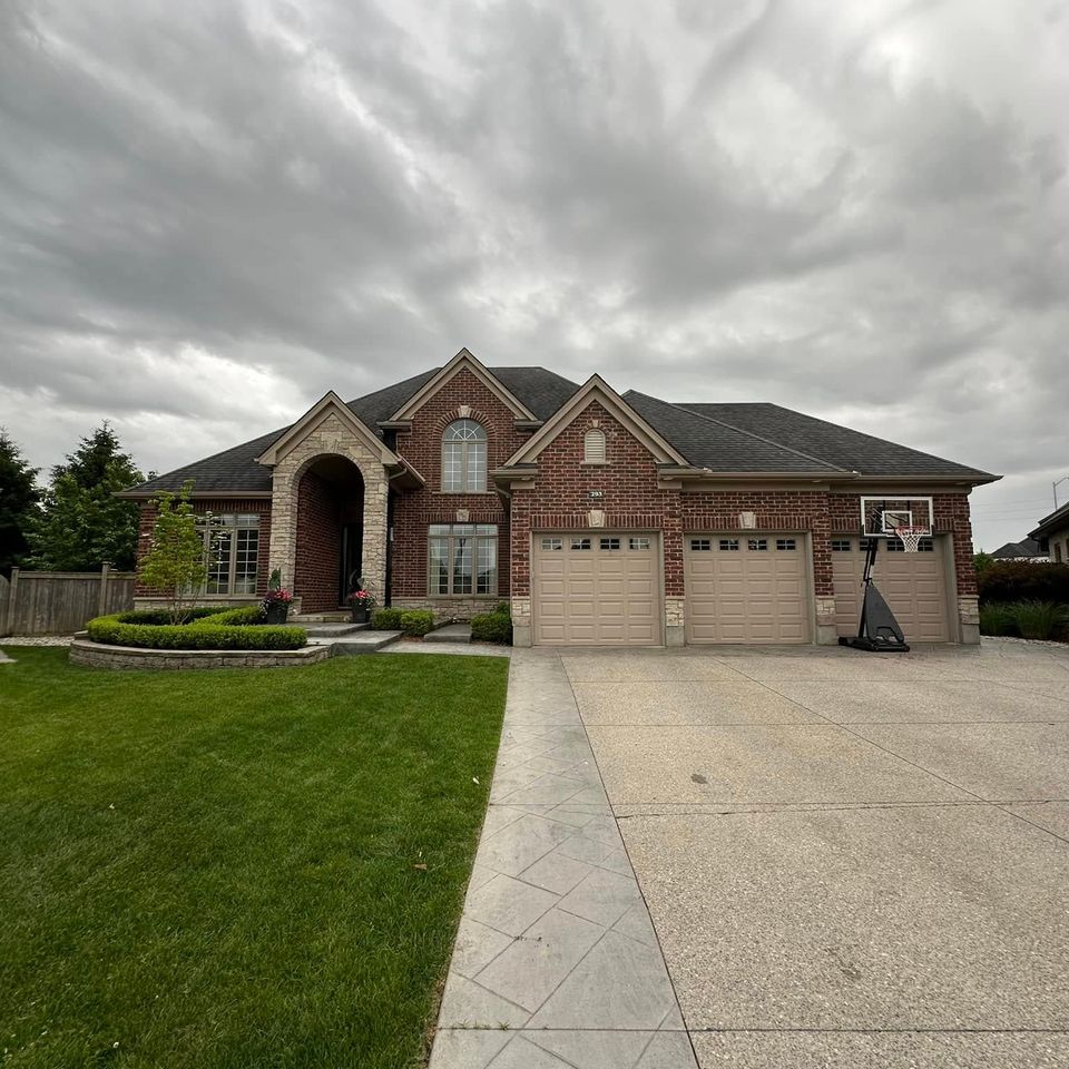 Brick home with clean windows and sealed stamped concrete driveway on a Tillsonburg Ontario property