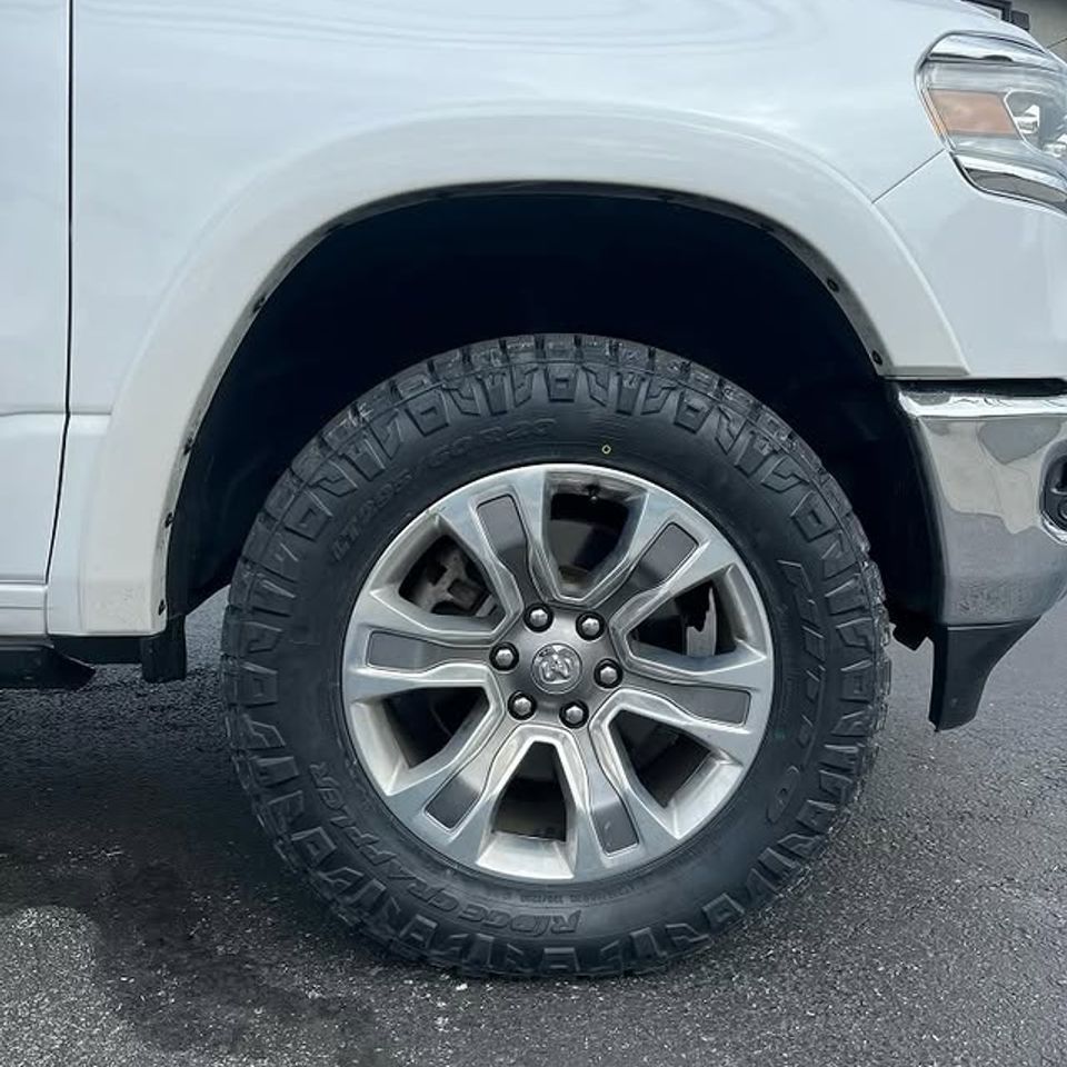 White Ram 1500 Hemi truck with new Ridge Grappler all-terrain tire and silver alloy wheel in Claymont DE