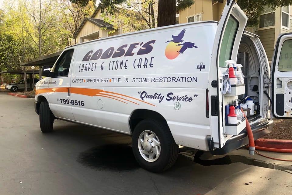 Goose’s Carpet & Stone Care service van with cleaning equipment and branding parked at a residential job site