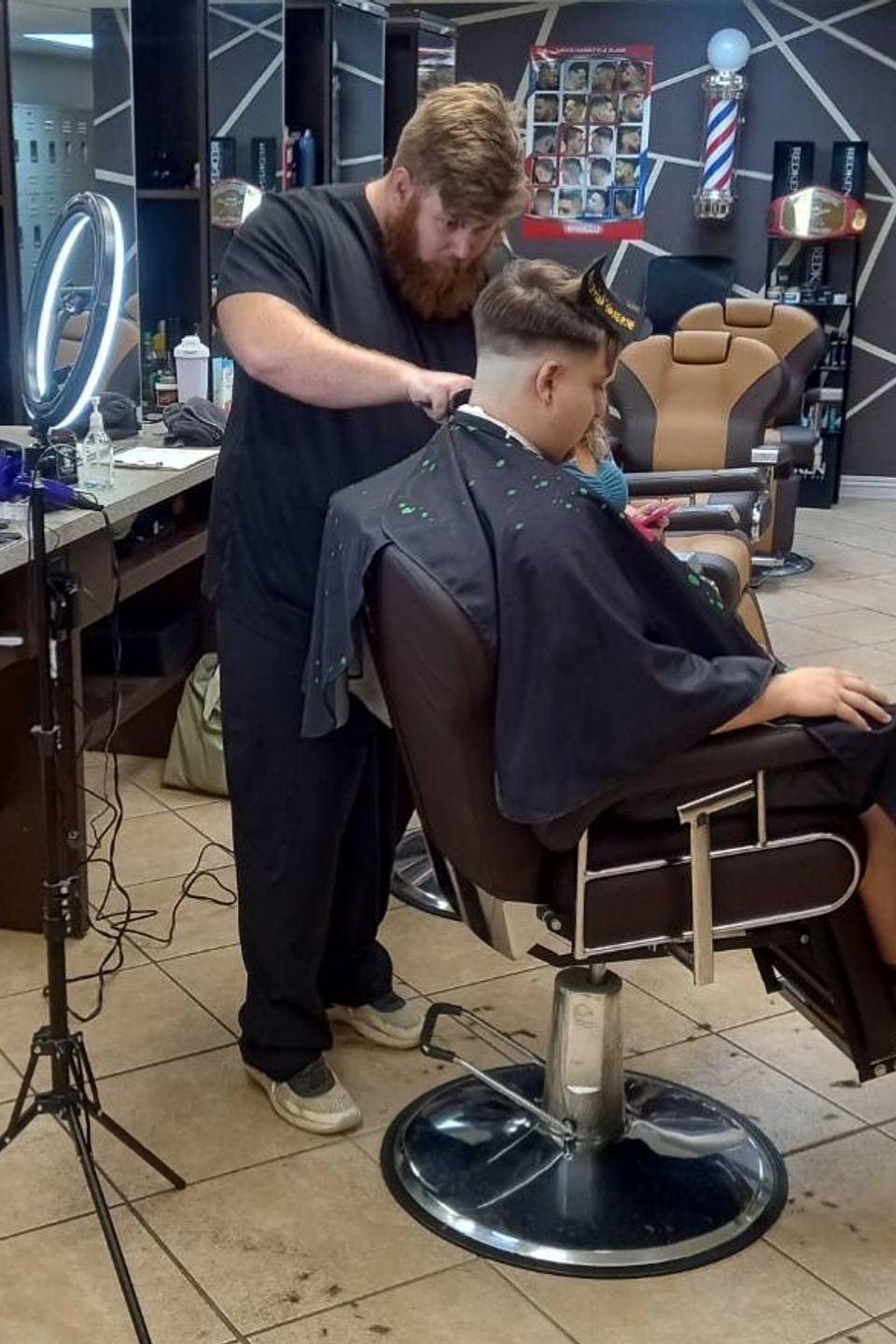 Student barber providing grooming service in training salon