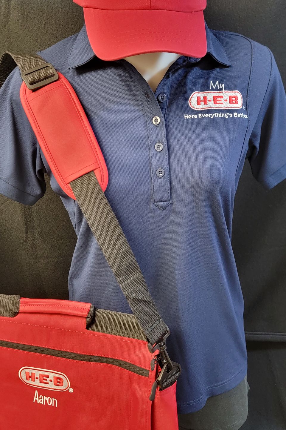 HEB Logo applied to blue shirt, red cap, and laptop bag bt SaRi's Creations