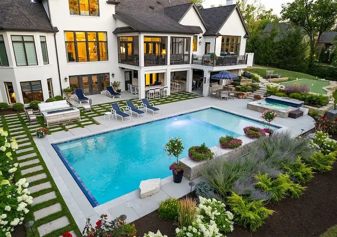 Luxury pool and outdoor living backyard design in Lake Norman with custom hardscaping, patios, landscaping, and entertainment areas