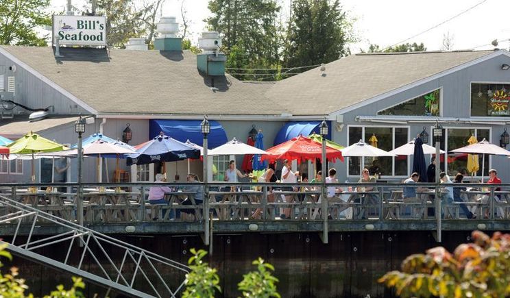 Waterfront outdoor deck seating at Bill's Seafood on the Patchogue River
