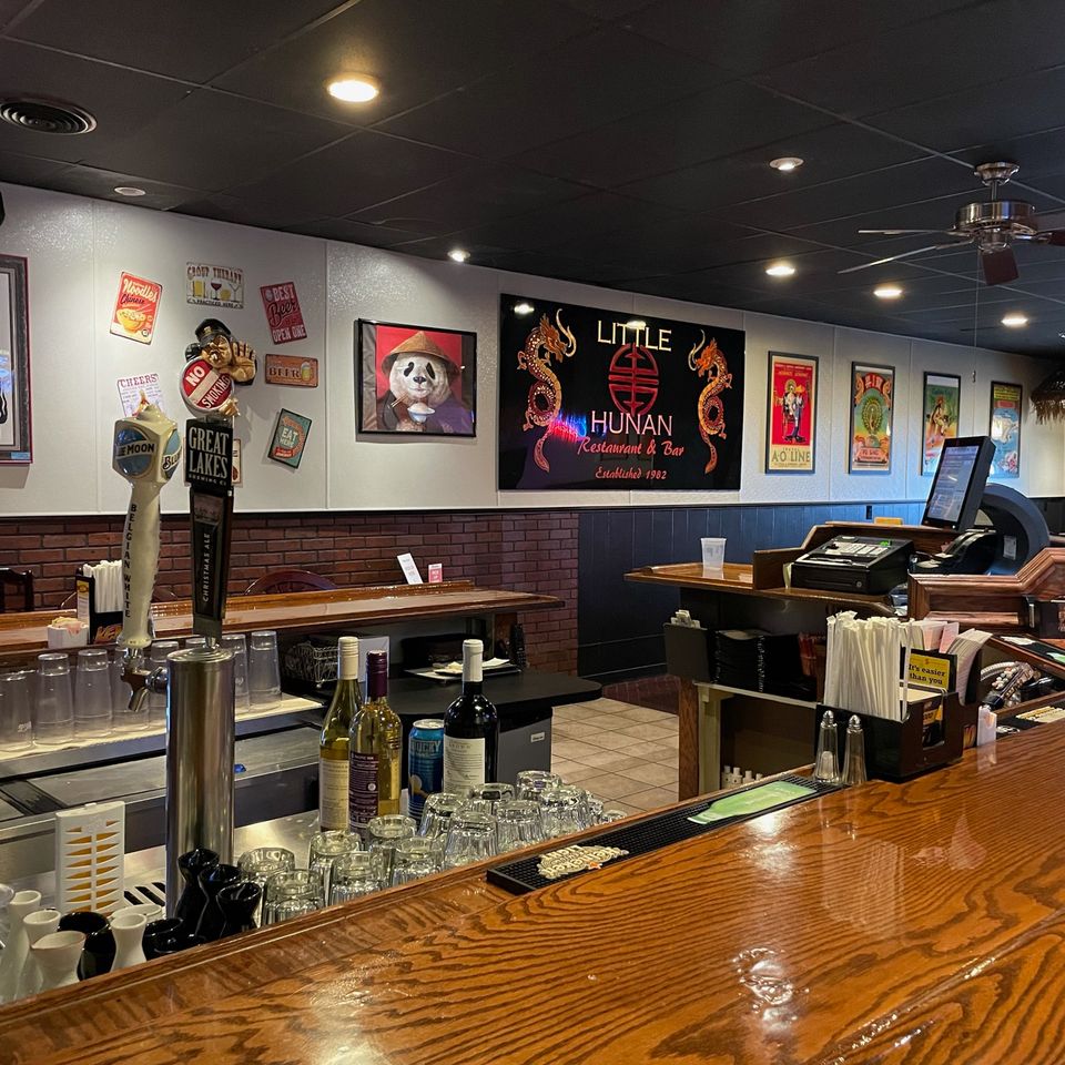 Interior view of Little Hunan Restaurant featuring the bar area, seating, and welcoming dining environment.