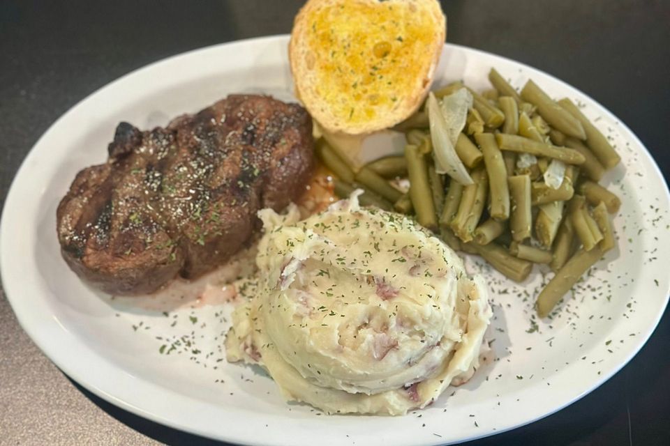 Grilled black angus filet served with garlic mash potatoes, vegetables and garlic bread.