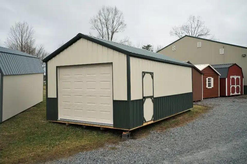 Cream and green cottage garage with white overhead door on a Elizabethton TN sales lot