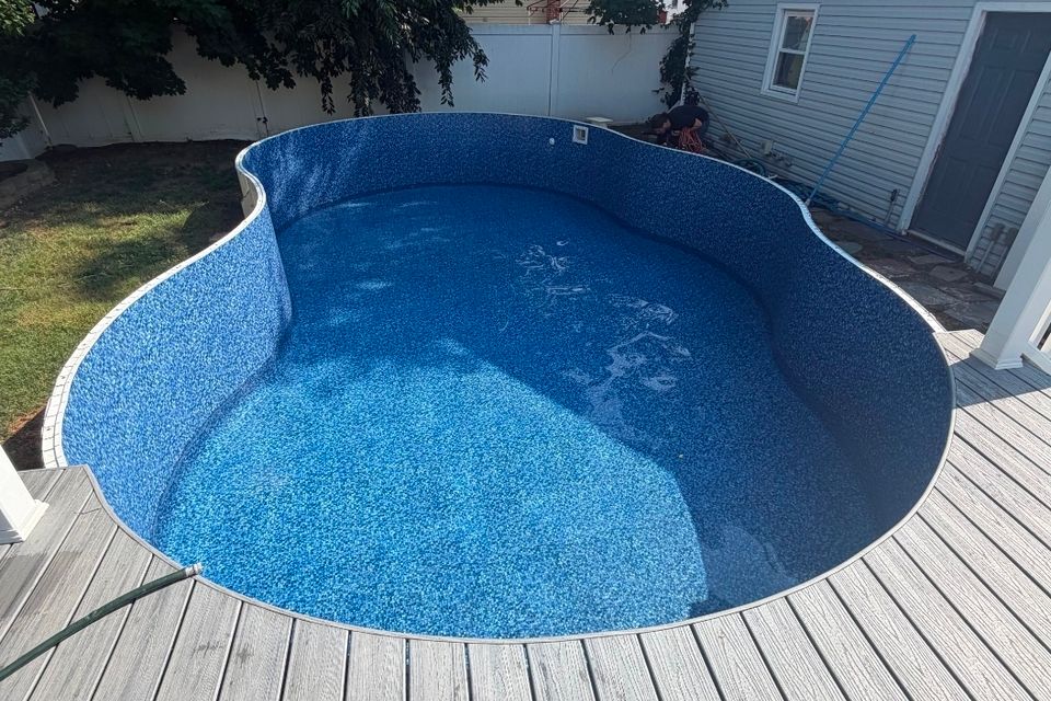 Freeform inground pool with new liner surrounded by a composite deck