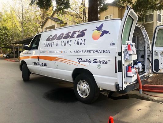 Goose’s Carpet & Stone Care service van with cleaning equipment and branding parked at a residential job site