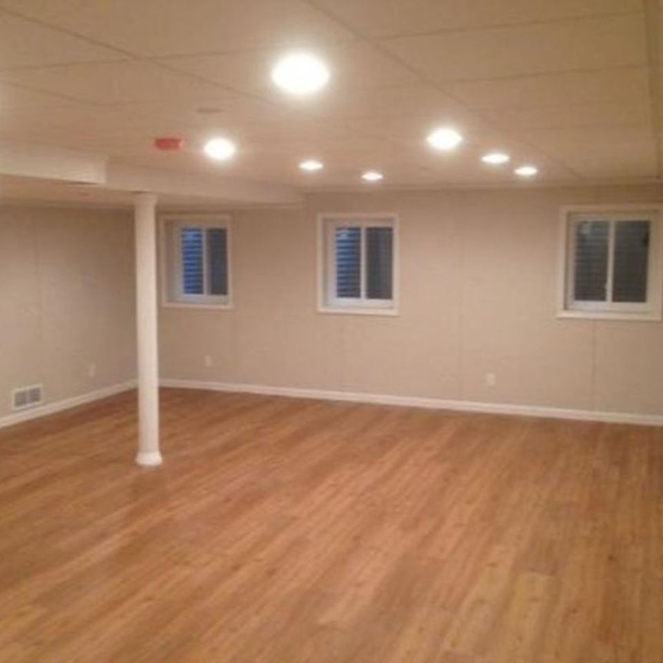 A basement remodel with hardwood floors and bright lighting done by Taurus Contracting Inc