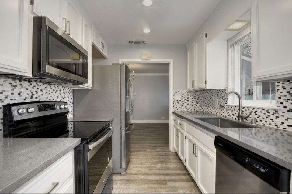 A bright, modern kitchen featuring professionally installed recessed ceiling lights, under-cabinet lighting, and dedicated circuits for stainless steel appliances.