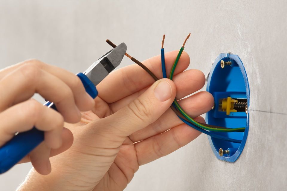 Stock photo hand of electrician striping the insulation of wires 558254197