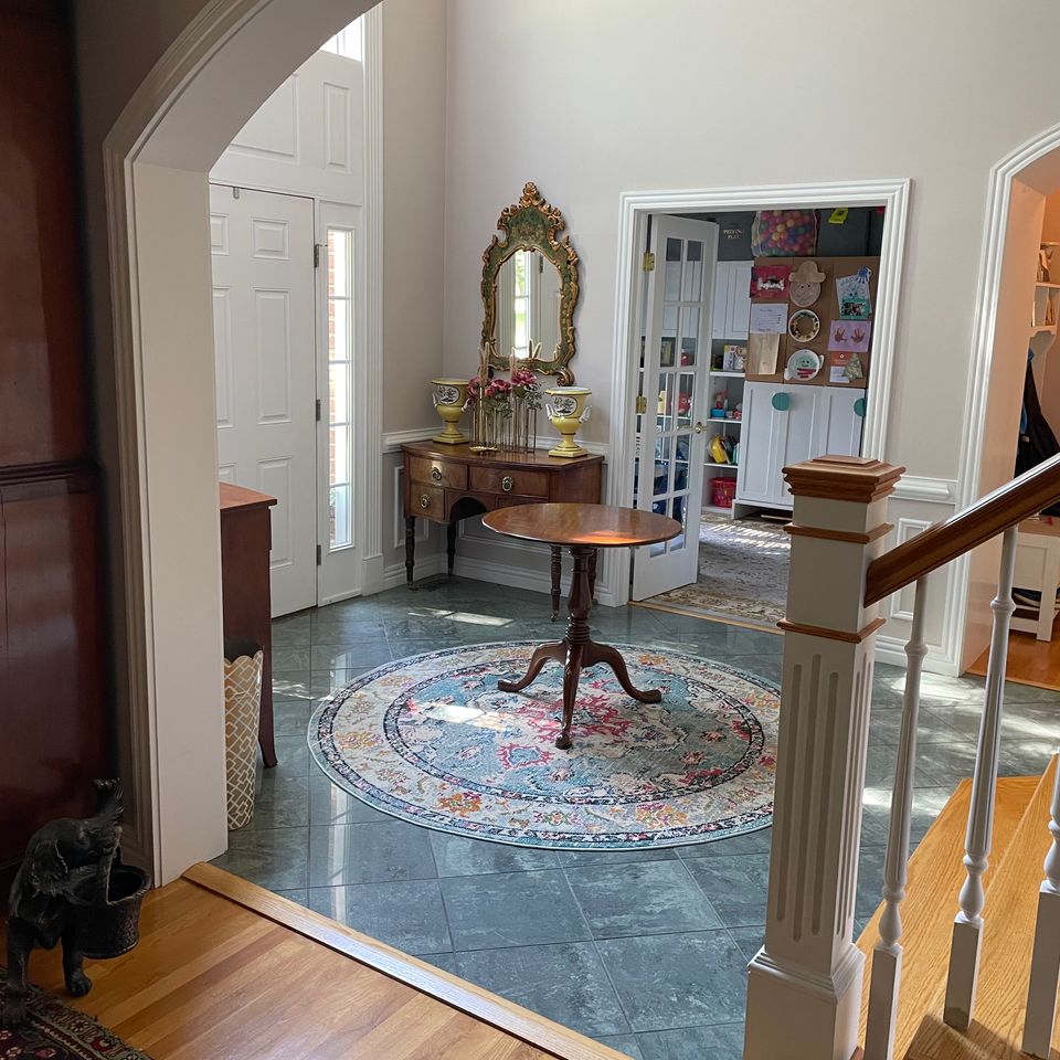 Sparkling clean tiled foyer with console table and area rug after a house cleaning service in Virginia Beach VA