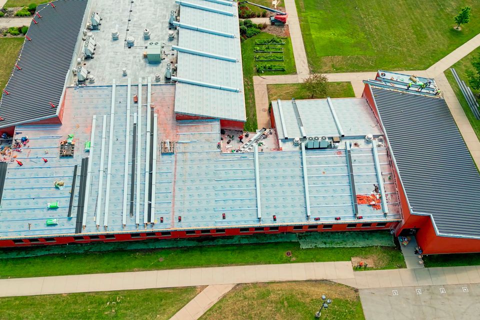Drone view of an industrial roof roofers installing a new roof on an industrial buildi sbi 350862692
