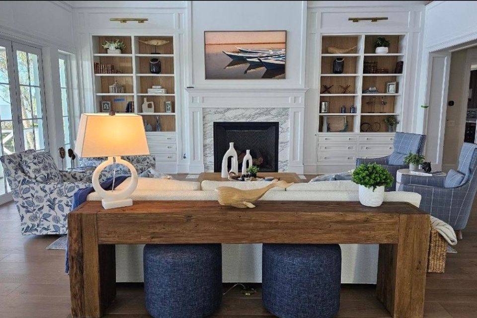 Living room with custom white built in cabinets flanking a marble fireplace