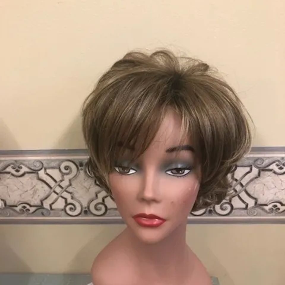 Short brunette wig with layered volume and feathered styling displayed on a mannequin at Shears Wigs & Hairpieces Salon.