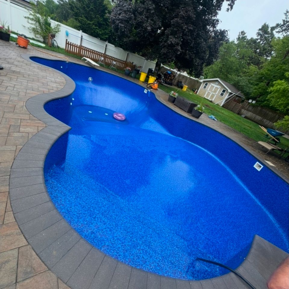 Freeform inground pool filling with water after liner replacement at a Long Island NY property