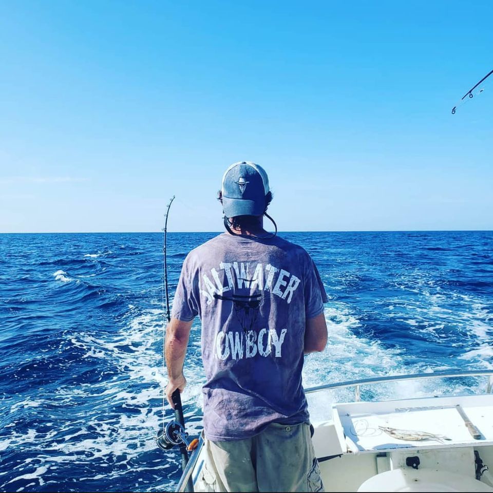 Angler on a boat fishing wearing a Saltwater Cowboy shirt