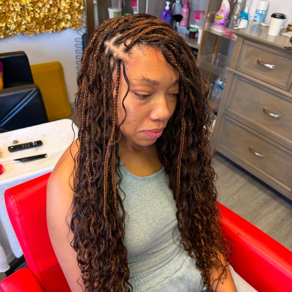 Client with long brown boho knotless braids with curly ends after braiding service in Los Angeles CA