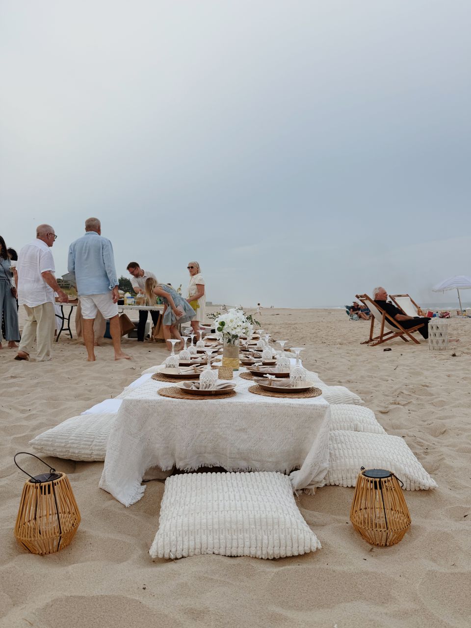 Beachside low table with white linens and floor cushions styled for a family gathering in the Hamptons