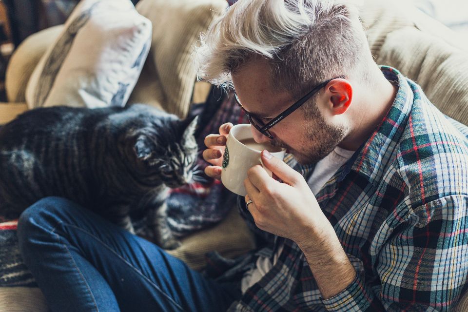 Man with glasses hanging out with his cat before his eye exam in Cypress, Texas