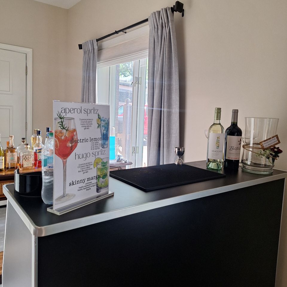 Full bar setup with spirits, wine bottles, and drink station for a social event