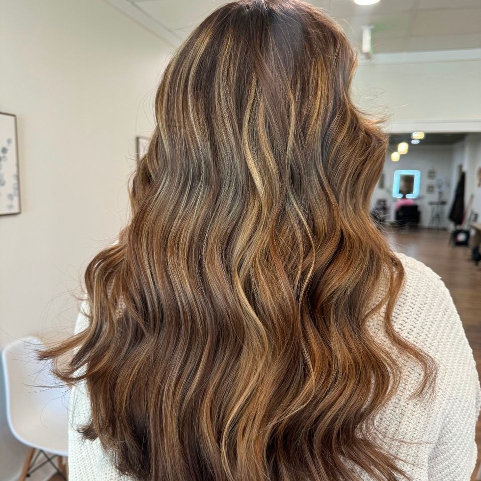 Long wavy brown hair with warm caramel highlights after color and styling in Columbiana AL