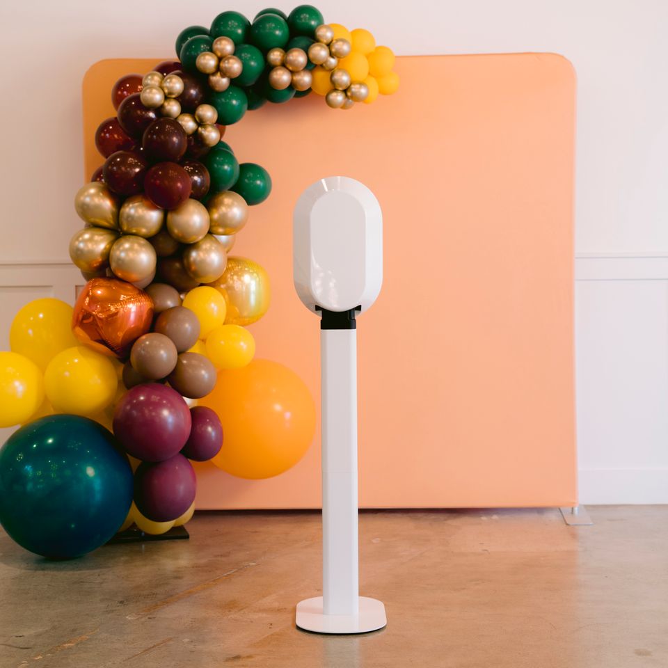 Digital photo booth setup with balloon arch backdrop at an indoor event