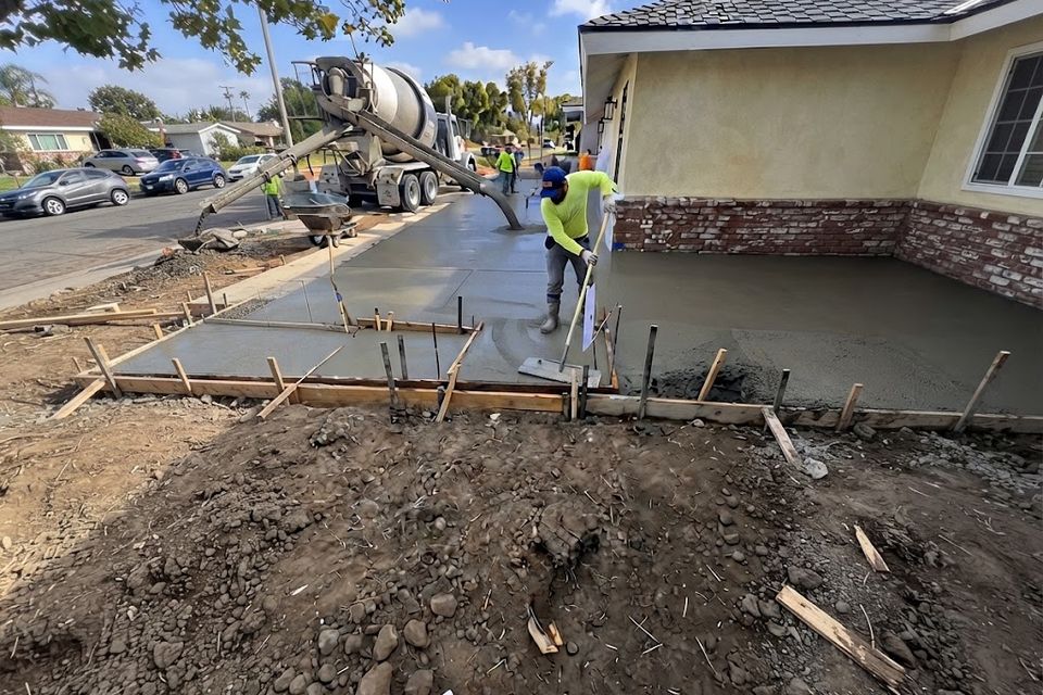 Concrete contractor pouring and finishing a new driveway in Orange County