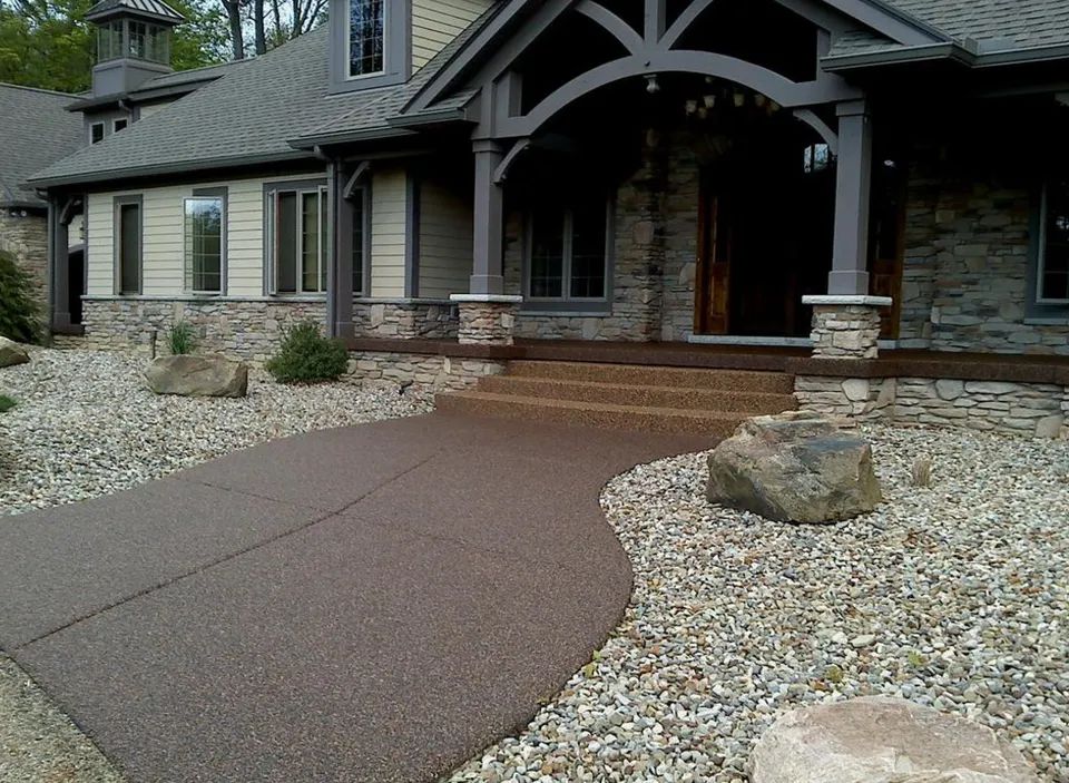 Front entrance and curved walkway finished with stone epoxy flooring leading to a residential home.