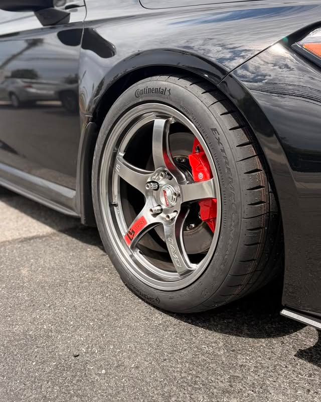 Close-up of sports car wheel with Continental tire and red Brembo brake caliper in Claymont DE