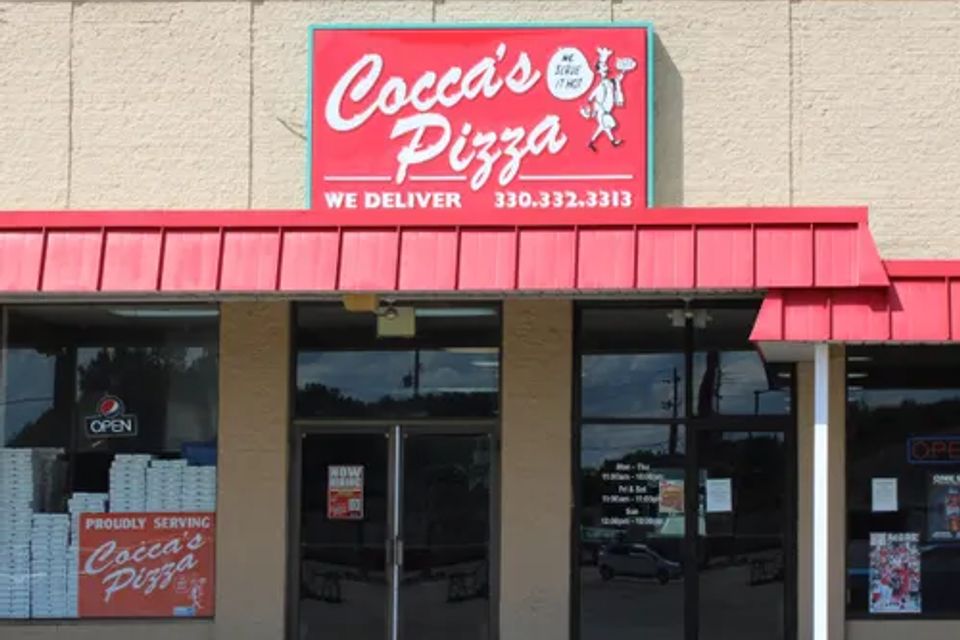 Cocca’s Pizza Salem, Ohio storefront featuring a tan exterior, red awning, glass entrance doors, and a large Cocca’s Pizza sign above the entrance.