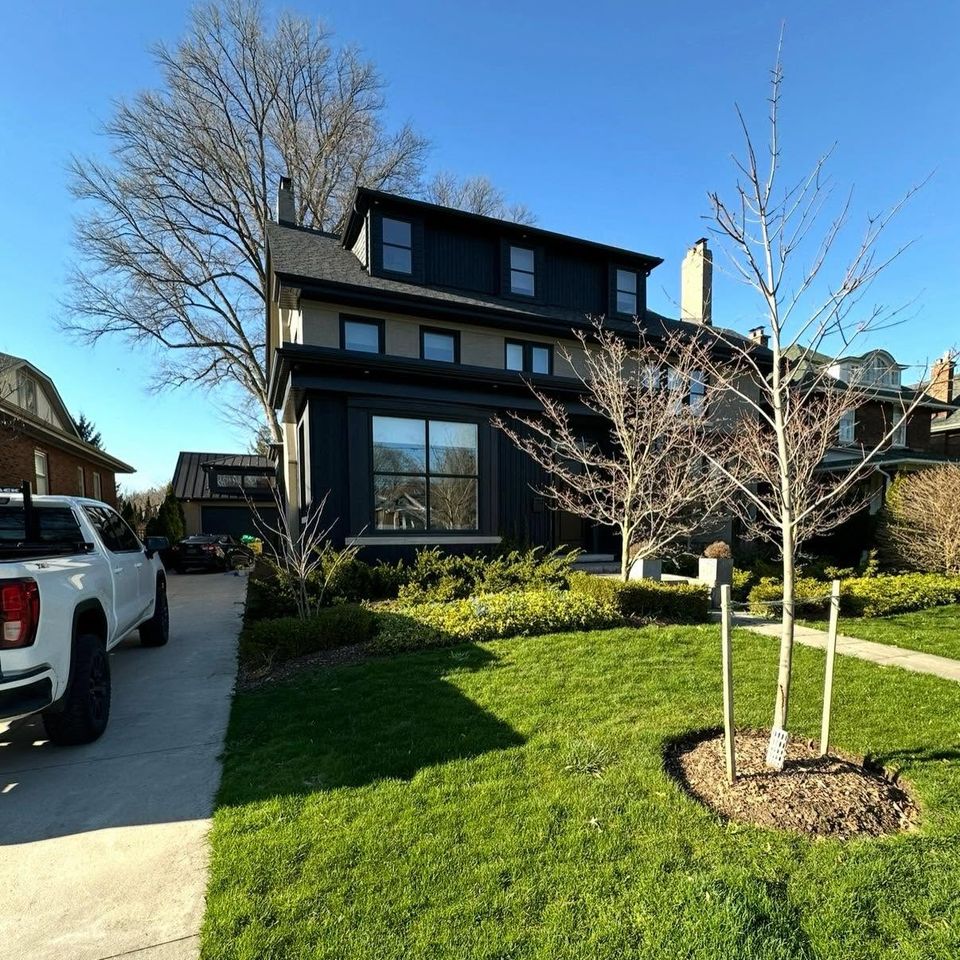 Black board and batten three-storey home with clean windows after exterior cleaning in Tillsonburg