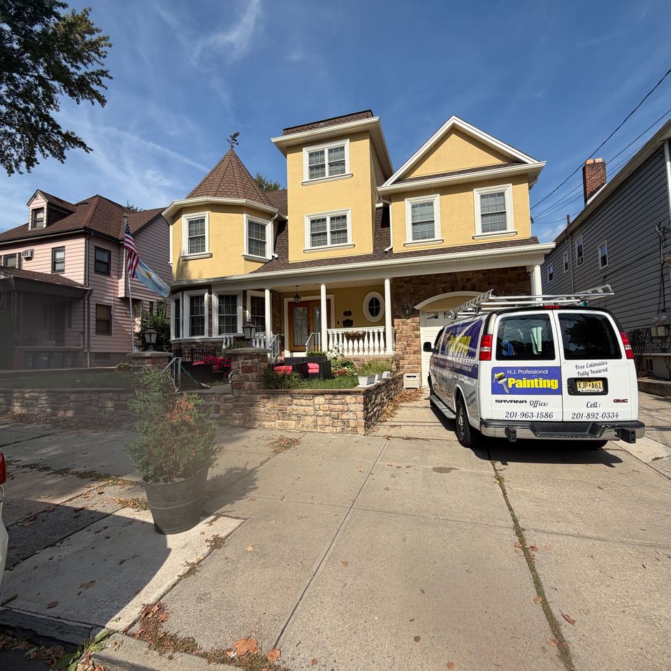 Exterior residential painting of a multi-level home with warm rich yellow wheat color paint