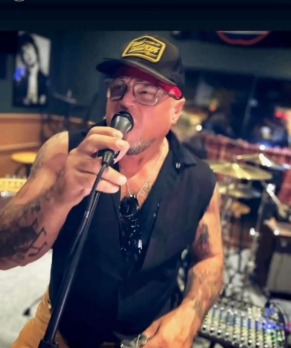 Roadside lead singer performing into a microphone at a Long Island pub gig