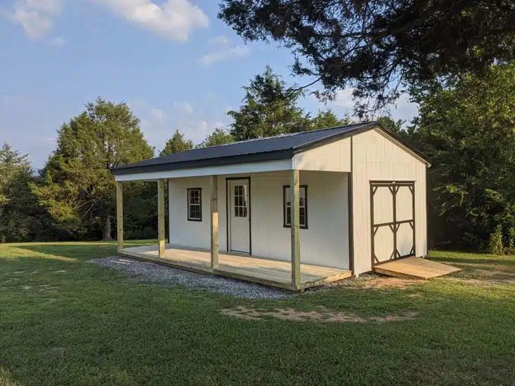 White country cabin with full length covered porch and side barn doors in Elizabethton TN