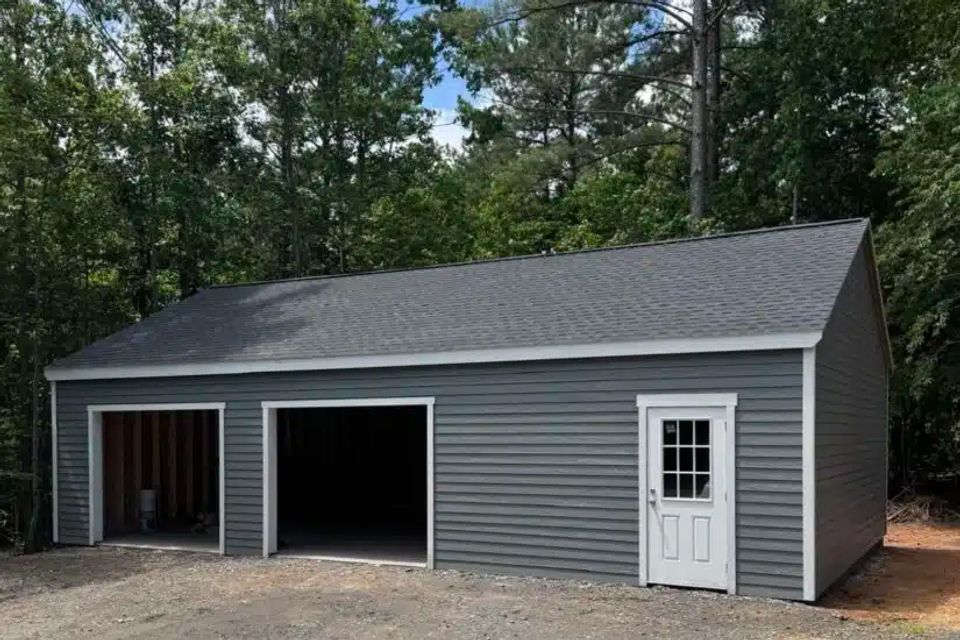 Gray double-wide garage with two open bays and shingle roof on a Knoxville TN property