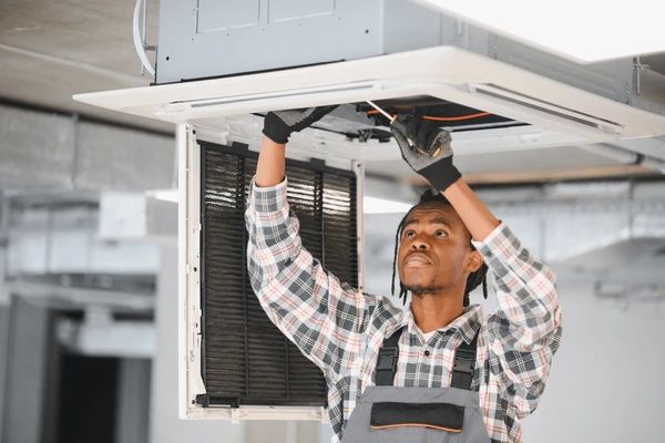 African american hvac technician repairing 600nw 2681324711