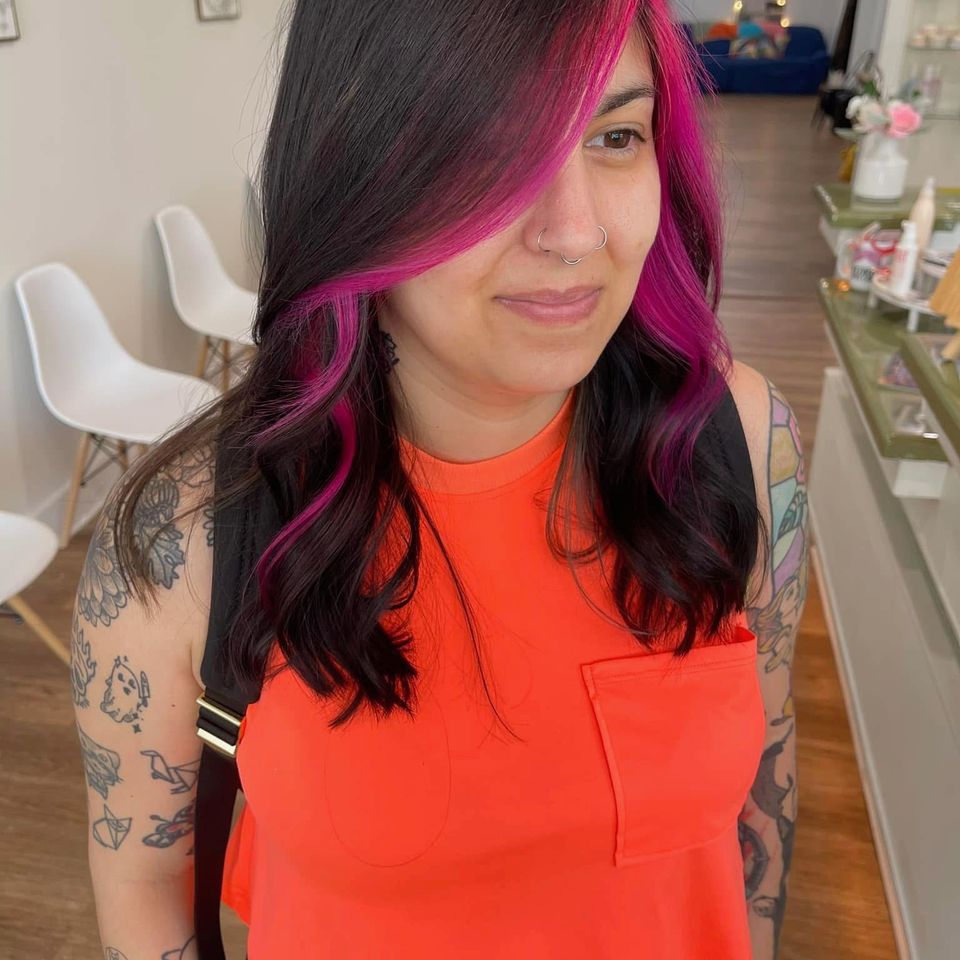 Dark hair with vivid magenta money piece framing the face after color service in Columbiana AL