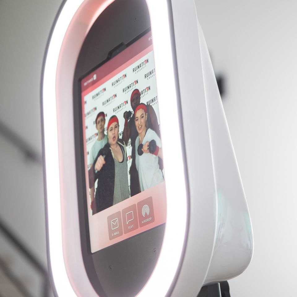 Digital photo booth with touchscreen showing photo preview and sharing icons.