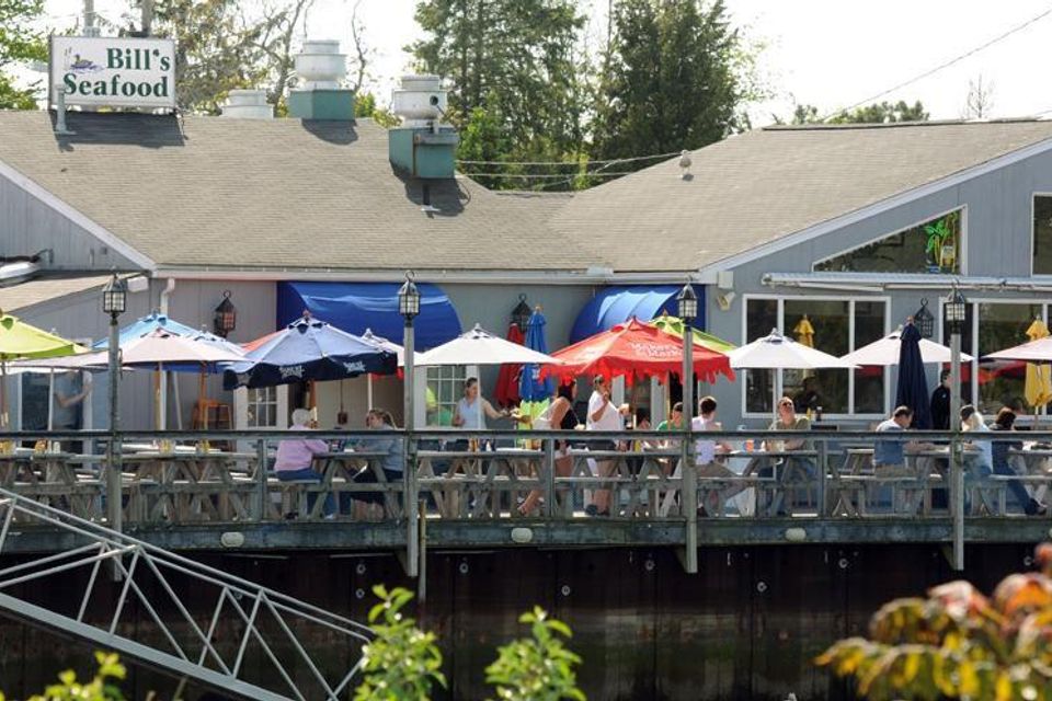 Waterfront outdoor deck seating at Bill's Seafood on the Patchogue River