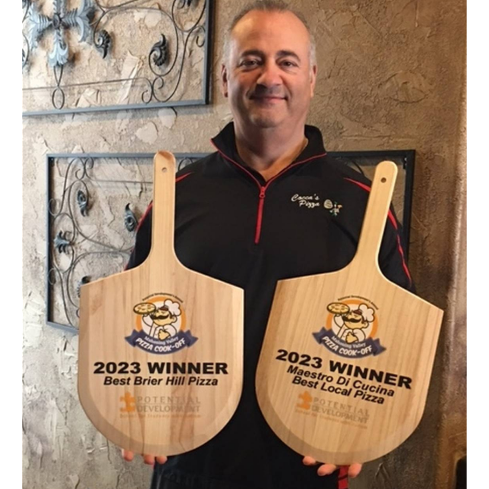 Steve holding pizza awards earned by Cocca’s Pizza.